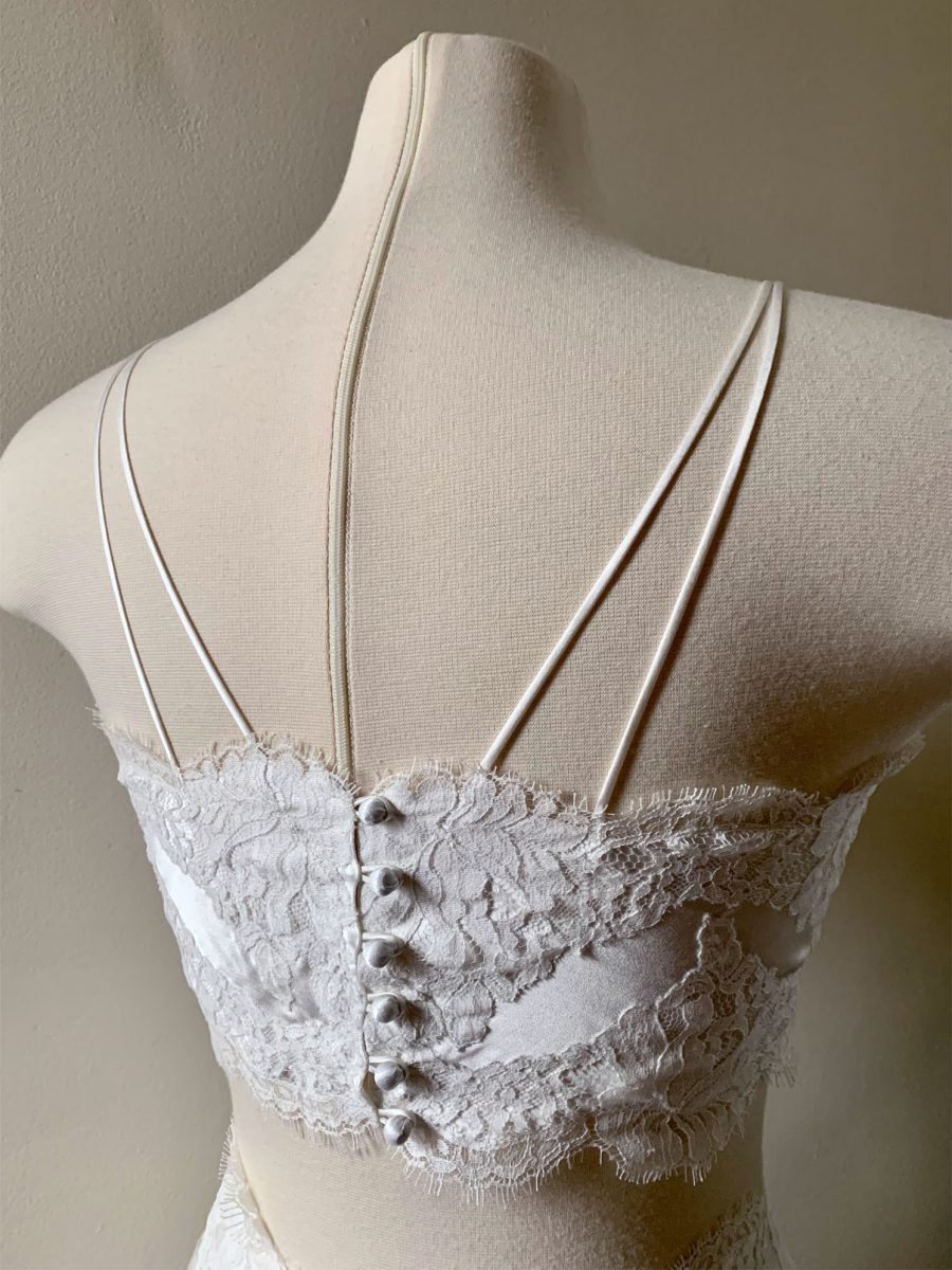 Back of Layneau Amélie bralette showing lace, silk rouleaux straps and silk-covered buttons